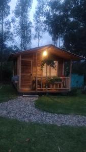 una cabaña de madera con una luz encima en Casa de leña, cabaña rural, en Villa de Leyva