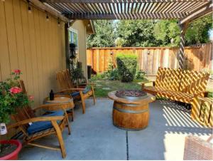 a patio with chairs and tables and a wooden pergola at Hollister Home Stay in Hollister
