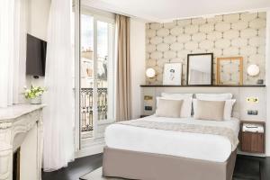 a white bedroom with a bed and a window at Best Western Plus La Demeure in Paris