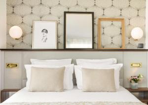 een slaapkamer met een bed met witte kussens bij Best Western Plus La Demeure in Parijs