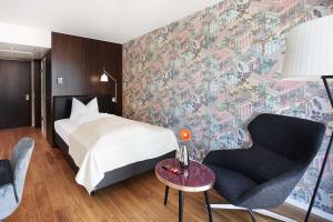 Un pat sau paturi într-o cameră la Parkhotel Heilbronn