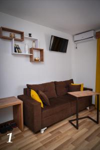 salon z brązową kanapą i stołem w obiekcie Studio apartmani Emili Bijeljina apartman br 1 w mieście Bijeljina