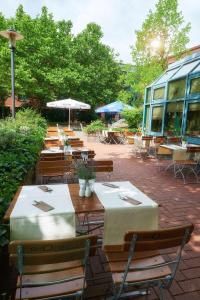 a patio area with chairs, tables and umbrellas at GHOTEL hotel & living Hannover in Hannover