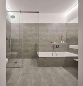 a bathroom with a shower and a bath tub at Flowers Hotel Essen in Essen