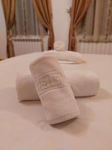three folded towels sitting on top of a bed at Tribunei Apartment Sibiu in Sibiu