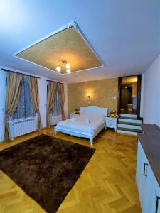 a bedroom with a white bed and a staircase at Tribunei Apartment Sibiu in Sibiu