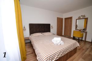 a bedroom with a bed with two towels on it at Studio apartmani Emili Bijeljina apartman br 1 in Bijeljina