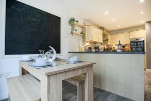 una cocina con una gran pizarra en la pared en Large 6 Bedroom House with Free Parking, Smart TV with Netflix, Fast Wifi, Air Hockey & Garden by Yoko Property en Milton Keynes