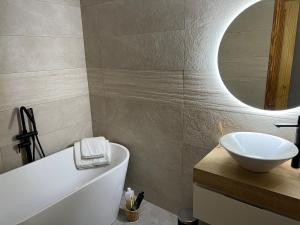 a bathroom with a sink and a tub and a mirror at Altea Lighthouse in Altea
