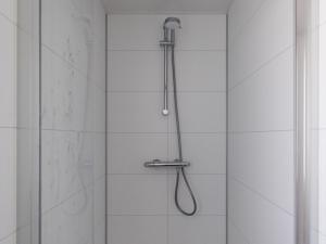 a shower with a shower head in a bathroom at Chalet by Pond in Eindhoven Holiday Park in Veldhoven +24 photos