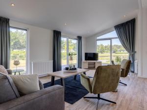 a living room with a couch and a table at Beautiful chalet with a bath, in a holiday park in the Brabant Kempen in Veldhoven