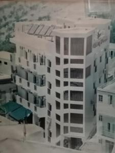 a tall white building with a lot of windows at HOTEL FADOUA in Moulay Yacoub