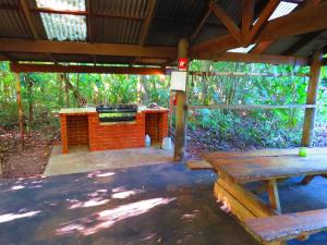 a pavilion with a picnic table and a bench at Daintree Rainforest Retreat Motel in Cape Tribulation