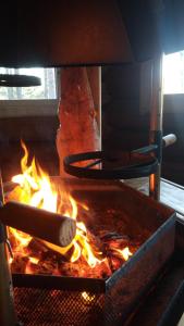 a stove with a grill with fire in it at Villa Nangu in Inari
