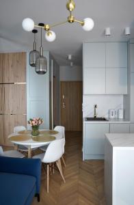 a kitchen and dining room with a table and chairs at Apartamenty METRO TARGÓWEK 27 in Warsaw