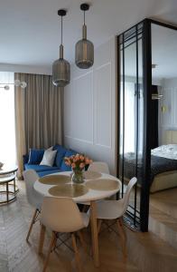 a living room with a table and a blue couch at Apartamenty METRO TARGÓWEK 27 in Warsaw