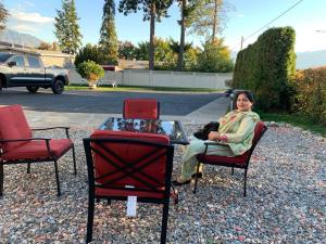 a woman sitting in a chair next to a glass table at City Centre Motel in Creston