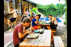 a group of people sitting at a table eating food at Cacao Hostel Santa Marta in Santa Marta