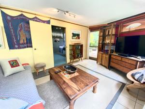 a living room with a coffee table and a tv at Butterfly Studio in Proserpine