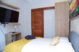 una camera da letto con un letto, una TV e una porta di S1404 Vista espectacular Downtown Santo Domingo a Santo Domingo
