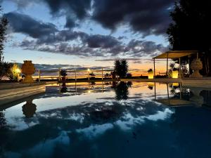a pool of water with a sunset in the background at Monte dos Poços in Aljustrel