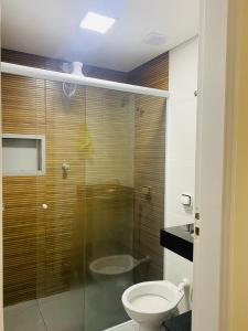 een badkamer met een toilet en een glazen douche bij Apartamento Praia Guarujá in Guarujá