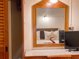 a bedroom with a mirror and a computer on a desk at Bonny Hotel 4 Floors No Elevator in Lamai