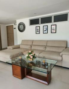 a living room with a couch and a glass table at Hotel Suramericana in Medellín