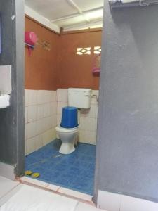 a bathroom with a toilet with a blue seat at Durian Chalet in Kuala Tahan