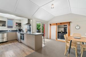 an open kitchen and dining room with a table and chairs at Cromwell Cutie - Cromwell Holiday Home in Cromwell