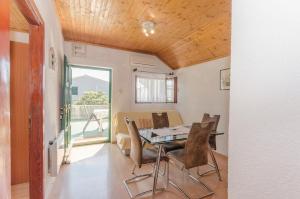 a dining room with a table and chairs at Apartments Romic in Jadrija