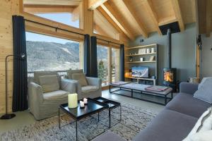 a living room with a couch and chairs and a fireplace at Chalet Aramis in La Tzoumaz