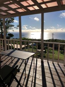 a porch with a table and a view of the ocean at PANORAMA Ocean View Cottage in Motobu