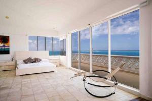 a bedroom with a bed and a view of the ocean at Penthouse Barlovento para 19 personas in San Andrés