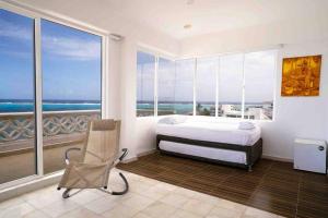 a bedroom with a bed and a view of the ocean at Penthouse Barlovento para 19 personas in San Andrés