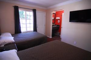 a hotel room with two beds and a window at Studio City Inn - Near Universal Studios Hollywood in Los Angeles