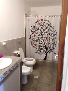 een badkamer met een douchegordijn met een boom erop bij Los Ceibos dpto para 4 personas in Estancia Vieja
