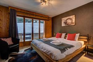 1 dormitorio con 1 cama grande con silla y ventana en Appartement Bellevue 207, en La Tzoumaz