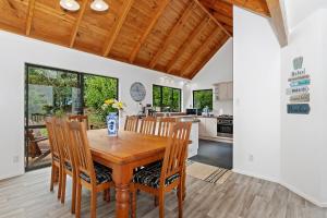 una cucina e una sala da pranzo con tavolo e sedie in legno di Brind Lodge - Russell Holiday Home a Russell