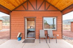 una piccola casa con due sedie e una camera da letto di Gooseberry Lodges Zion National Park Area a Apple Valley