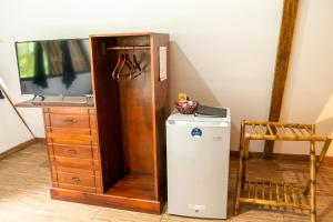 um pequeno frigorífico ao lado de uma televisão e uma cómoda em Hotel y Bungalows El Jardín em San Felipe