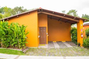 a small yellow house with a brown door at Hotel y Bungalows El Jardín in San Felipe