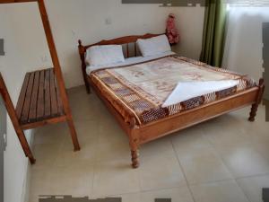 ein Schlafzimmer mit einem Holzbett und einem Stuhl in der Unterkunft Triple Eden Resort - Naivasha in Naivasha