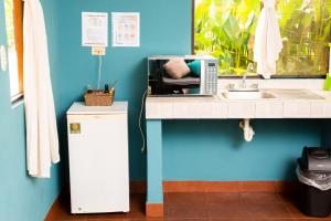 a kitchen with a sink and a microwave on a counter at Hotel y Bungalows El Jardín in San Felipe