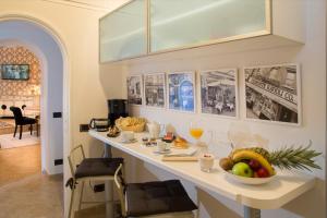 
a kitchen with a table, chairs, and a painting on the wall at The Inn At The Roman Forum in Rome
