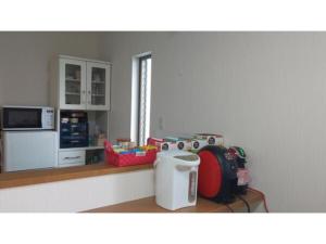 eine Küche mit einer Theke mit einem Kühlschrank und einer Mikrowelle in der Unterkunft Guest House Fukuchan - Vacation STAY 34483v in Kaiyo