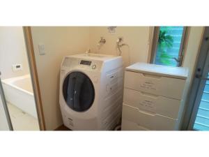 eine Waschmaschine im Bad neben einem Waschbecken in der Unterkunft Guest House Fukuchan - Vacation STAY 34483v in Kaiyo
