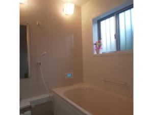 ein Bad mit einer Badewanne, einem Fenster und einem Waschbecken in der Unterkunft Guest House Fukuchan - Vacation STAY 34483v in Kaiyo