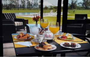 una mesa con platos de comida y dos vasos de zumo de naranja en Regency Park Hotel, en Montevideo