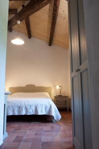 1 dormitorio con 1 cama en una habitación con techos de madera en Agriturismo Mirasole en Predappio